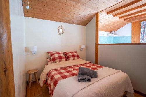 - une chambre avec un lit et une couverture en damier dans l'établissement La Tourtette, à Saint-Étienne-en-Dévoluy