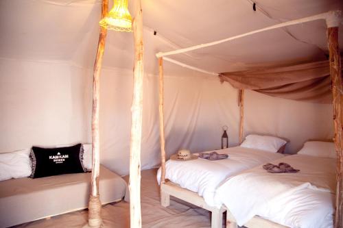 a bedroom with two beds in a tent at Kam Kam Dunes in Merzouga