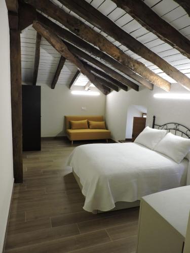 a bedroom with a white bed and a couch at Casas Piedra in Arredondo