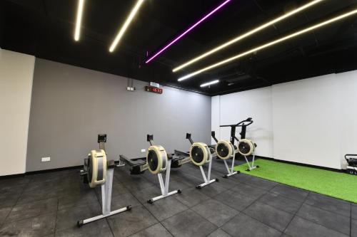 a gym with several treadmills and machines in a room at JUFFAIR BOULEVARD HOTEL & SUITES in Juffair