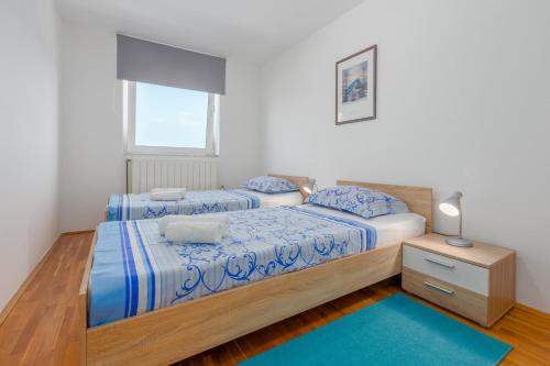 een slaapkamer met 2 bedden en een raam bij Bellavista Superior Funtana in Funtana