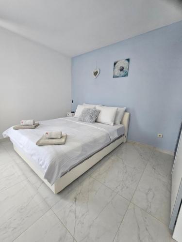 a white bedroom with a large bed with towels on it at Apartments Aurora in Jezera
