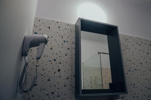 a mirror and a blow dryer in a bathroom at Pensiunea R&R Băilești in Băileşti