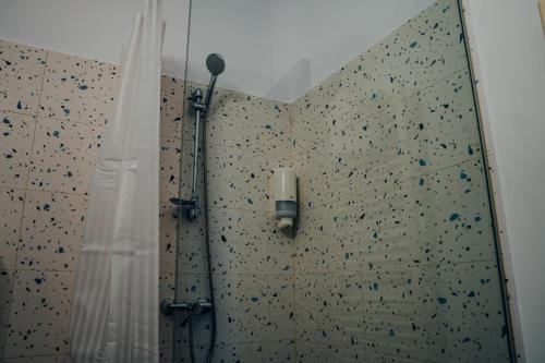 a shower with a rock wall in a bathroom at Pensiunea R&R Băilești in Băileşti