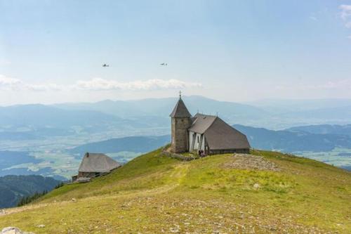 a church on top of a grassy hill at Apartment near Red Bull Ring in Pirkach