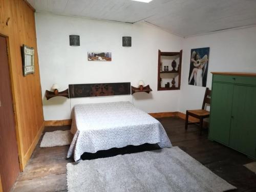 ブラガンサにあるCasal de Palácios- Françaのベッドルーム1室(ベッド1台付)、緑のキャビネットが備わります。