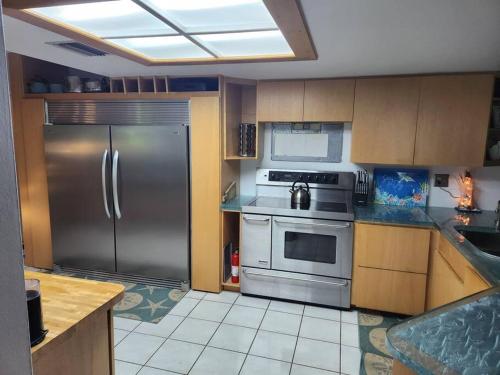 una cucina con frigorifero e armadietti in acciaio inossidabile di Hideaway in Serenity! a Clearwater
