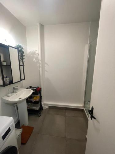 une salle de bain blanche avec un lavabo et une douche dans l'établissement BizFinding Paris, à Montrouge