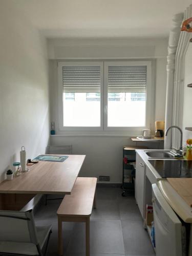 - une cuisine avec une table en bois et 2 fenêtres dans l'établissement BizFinding Paris, à Montrouge