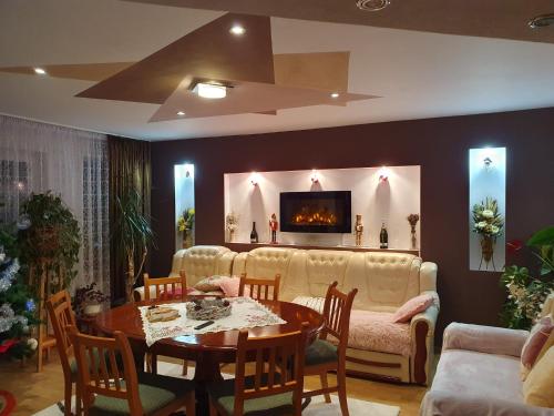 a living room with a white couch and a table at Edelweiss Ilinca in Zărneşti