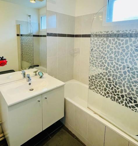 une salle de bain avec un lavabo, une baignoire et une douche dans l'établissement House Versailles & Olympic Centers, à Guyancourt