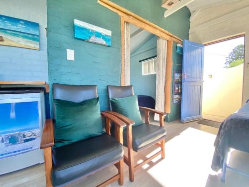 a room with two chairs and a tv and a bedroom at Agulhasbestview in Agulhas