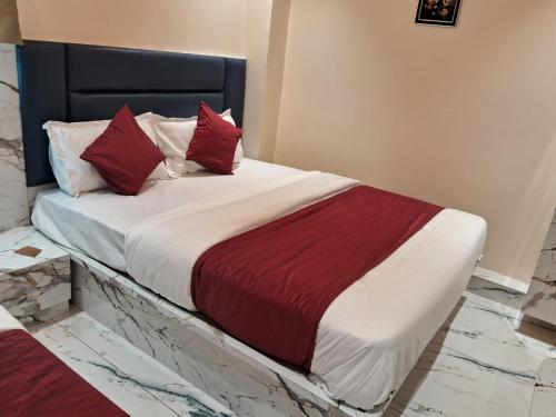 een slaapkamer met een groot bed met rode kussens bij HotelMeetPalace in Ahmedabad