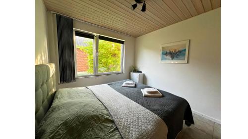 - une chambre avec un lit et 2 serviettes dans l'établissement Cozy Rødbyhavn Villa - Lalandia/Puttgarden/Femern, à Rødby
