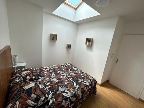 Cet appartement comprend une chambre dotée d'un lit et d'une lucarne. dans l'établissement Apt Albi 2 chambres climatisé plein centre et parking, à Albi