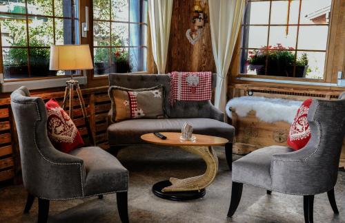 a living room with two chairs and a table at Hotel La Cambuse in Les Collons