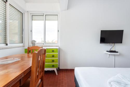 a bedroom with a desk and a bed and a tv at Blife Faro Beach Hostel & Rooms in Faro