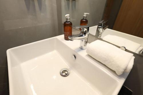 a white bathroom sink with a soap dispenser on it at Arjun - A boutique hotel in Haridwār