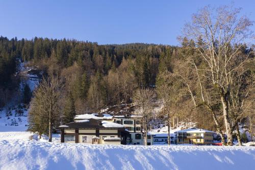 a house in the middle of a snow covered field at Bad Serneus Water Resort in Klosters