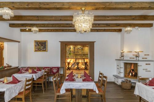 a dining room with tables and chairs and a fireplace at Bad Serneus Water Resort in Klosters