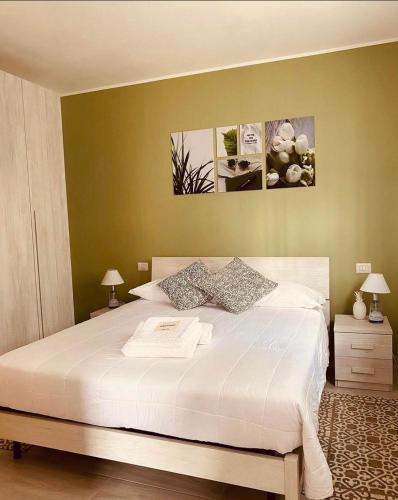 a bedroom with a large white bed with two lamps at Corte 22 B&b e Appartamenti in Borgomanero
