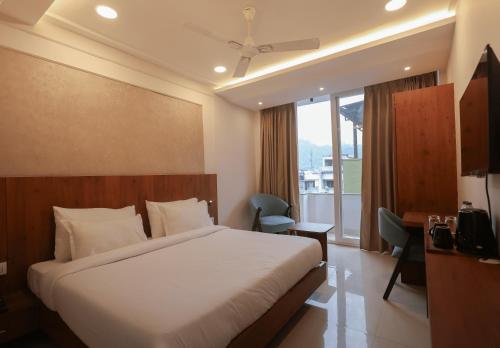 ein Hotelzimmer mit einem Bett und einem Balkon in der Unterkunft Arjun - A boutique hotel in Haridwar