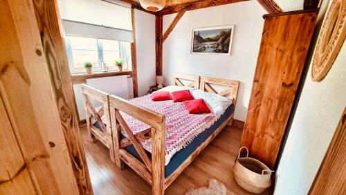 a small bedroom with a bed with red pillows at Twój Drugi Dom na Kaszubach in Załakowo