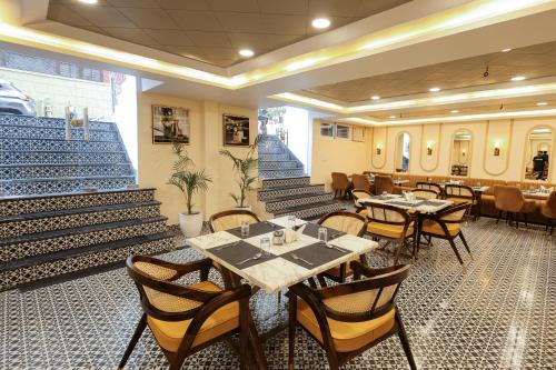 a dining room with tables and chairs and stairs at Arjun - A boutique hotel in Haridwār
