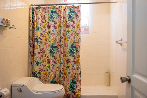 a bathroom with a shower curtain and a toilet at Best E Villas Prospect St James in Saint James