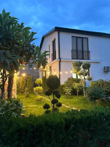 a white house with a garden in front of it at LARDA TBILISI in Tbilisi City