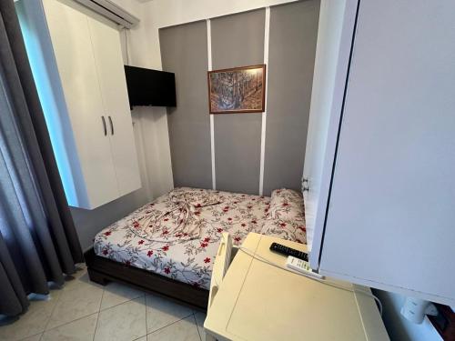 a small bedroom with a bed and a television at Eid Mar in Vlorë