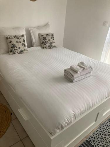 un lit blanc avec des serviettes dessus dans l'établissement Studio Cosy, LYON, avec garage privé, à Lyon