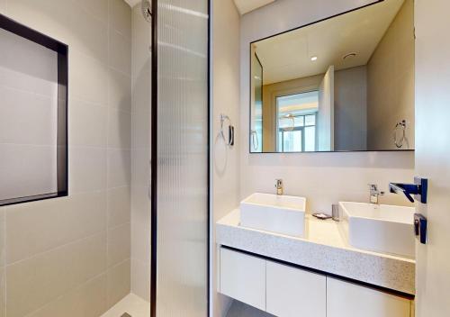 a bathroom with two sinks and a mirror at Amazing View Marina Vista High Floor in Dubai