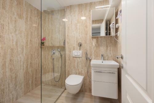 y baño con ducha, aseo y lavamanos. en Ocea apartments in the city center, en Kotor