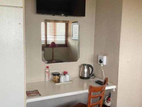 - un comptoir dans une pièce avec une table et un miroir dans l'établissement Jopasso Guest House, à Pretoria