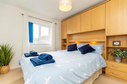 a bedroom with a large bed with blue towels on it at Comfortable and Spacious Superb Holiday Home in Llanelli, Dog Friendly in Llanelli