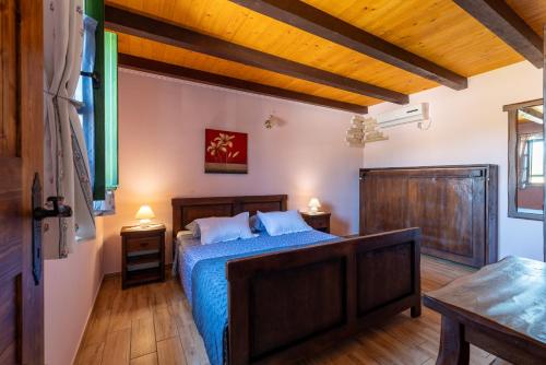 - une chambre dotée d'un lit avec des draps bleus et du parquet dans l'établissement Stone villa Tea with pool, à Posedarje