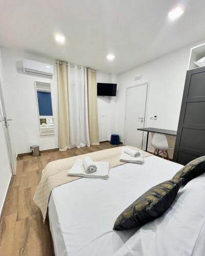a bedroom with a large bed with two towels on it at Easy Room in Catania