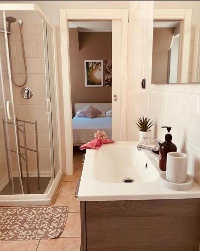 a bathroom with a sink and a shower and a bed at Corte 22 B&b e Appartamenti in Borgomanero