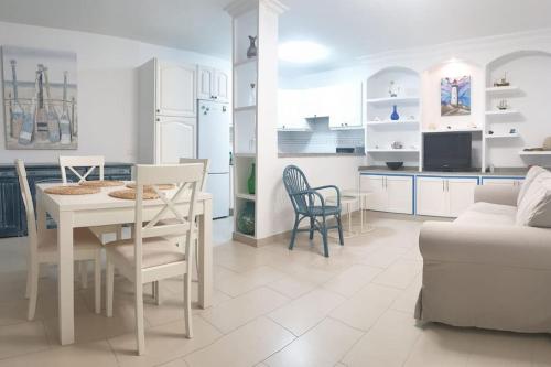 cocina y sala de estar con mesa y sillas en La Caleta casa junto al mar en Adeje