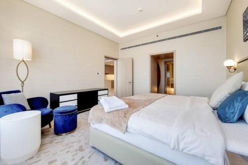 a white bedroom with a large bed and a desk at Splendor 1BR with Breathtaking Palm Views in Dubai