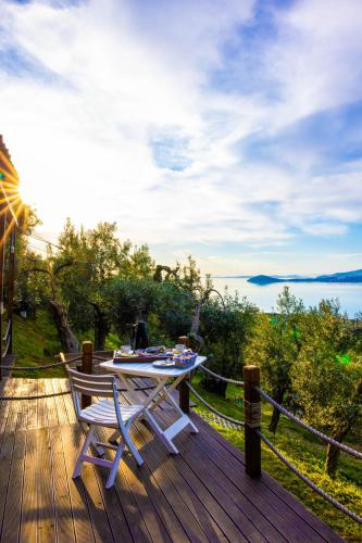 - une table et des chaises sur une terrasse en bois avec vue sur l'eau dans l'établissement Kiraz Sunset Bungalow Deluxe, à Bandırma