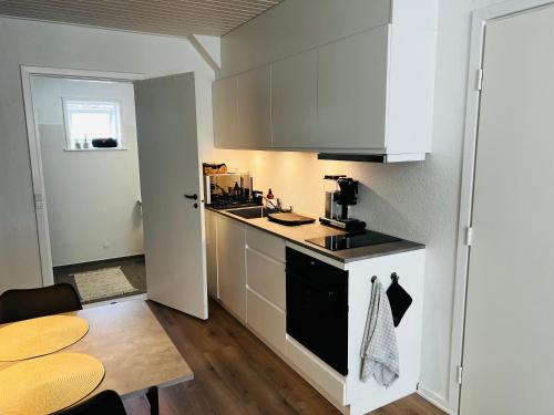 een keuken met witte kasten en een tafel in een kamer bij The Old Hotel Silkeborg - S1 in Silkeborg