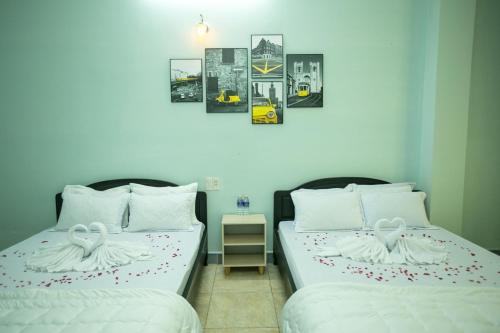 dos camas sentadas una al lado de la otra en una habitación en Nhà Nghỉ Kim Lài - Đối diện bệnh viện tỉnh Gia Lai -132 Tôn Thất Tùng en Pleiku