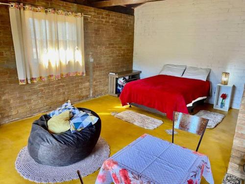 Habitación con cama, sofá y silla en Chalé Pedra Chanfrada 02, en Gonçalves