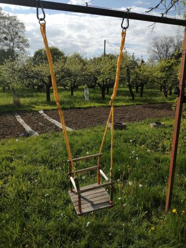 a swing in a field of grass with trees at Apartmán Vlčovice in Kopřivnice