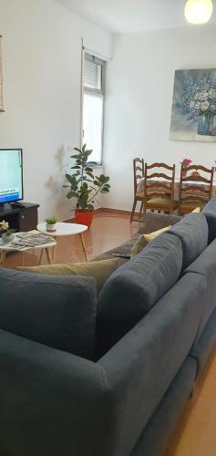 a living room with a blue couch and a table at City Center Apartment in Shkodër