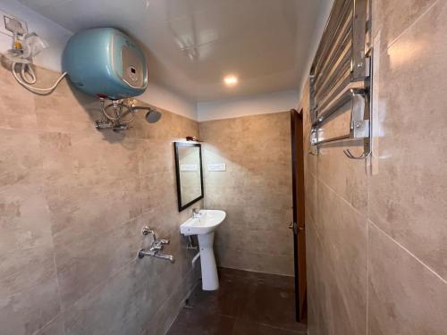 ein Bad mit einem Waschbecken und einem Spiegel in der Unterkunft The Lake Palm Hotel in Kalkutta