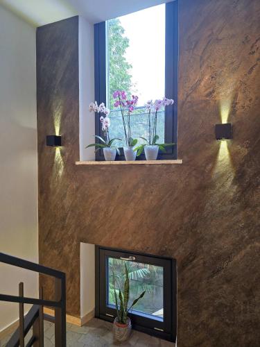 a living room with a fireplace and a window with potted plants at Art Garage Varese in Biandronno