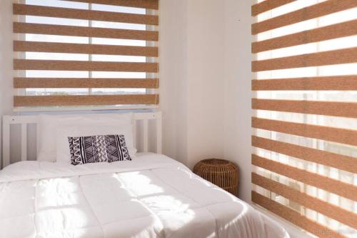 ein weißes Bett in einem Zimmer mit Fenster in der Unterkunft hei apartment in Bacolod City